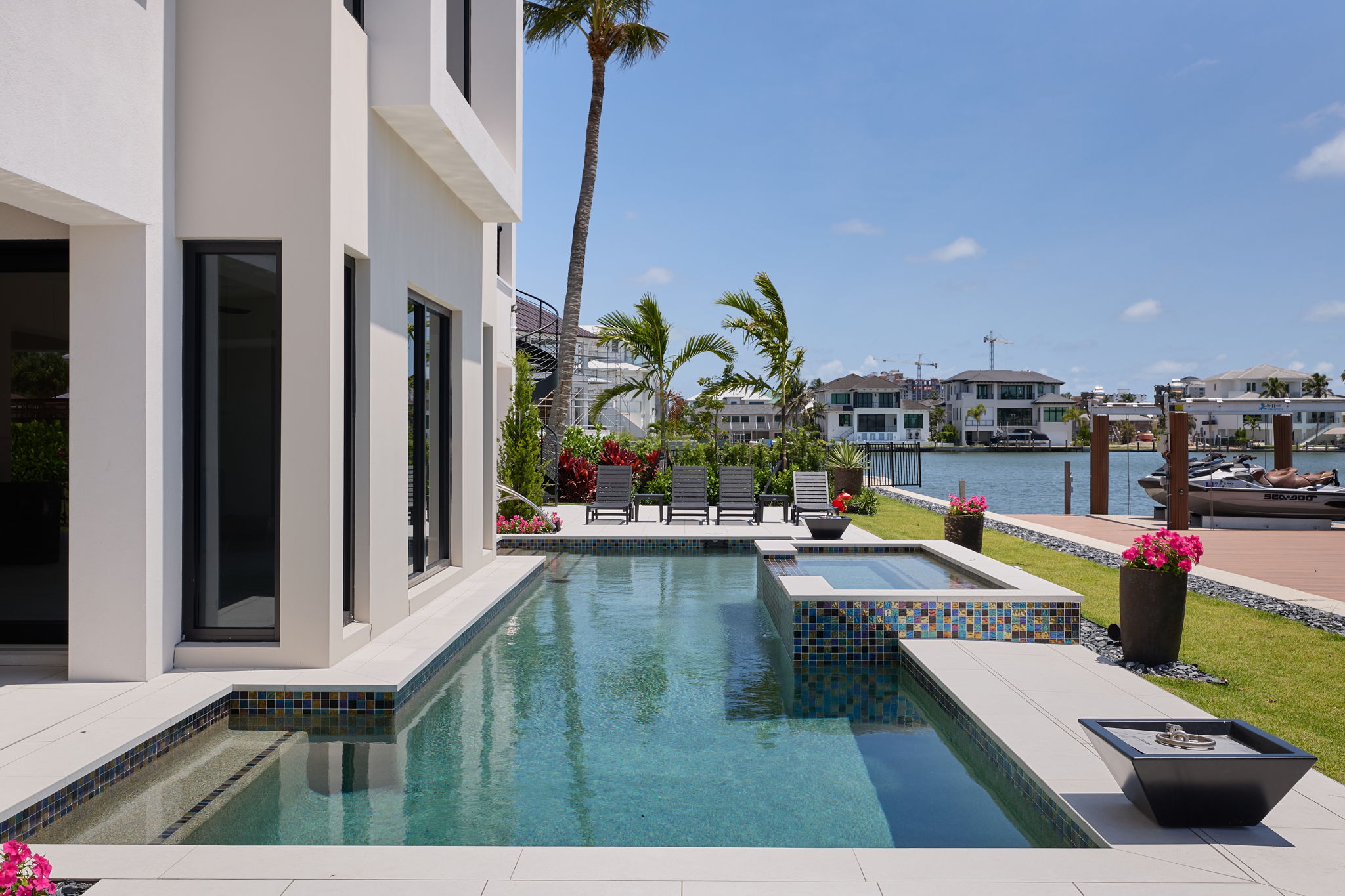 ES Homes pool terrace beside a modern Southwest Florida residence